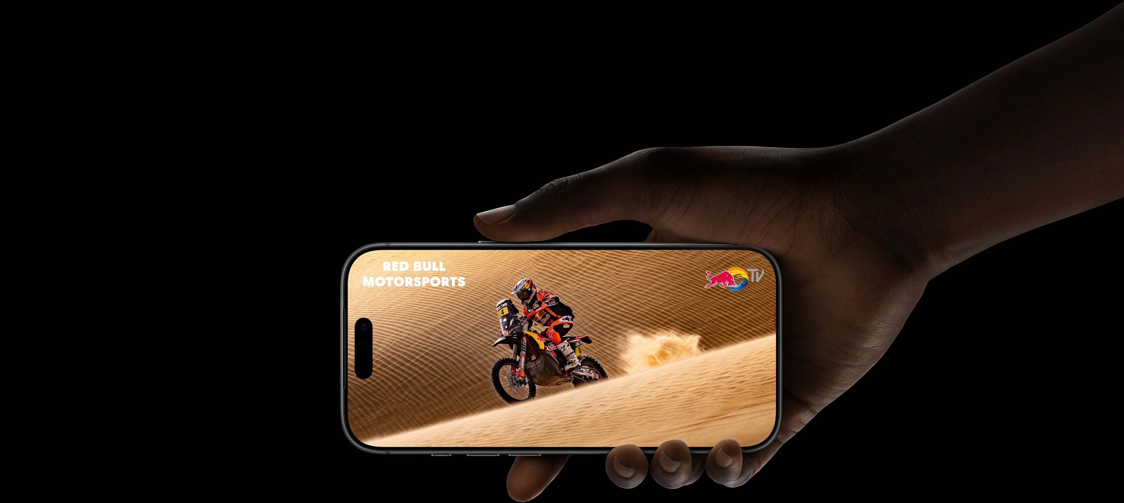 ASKY Digital iPhone 15 Pro showing Red Bull Motorsports video on desert dunes